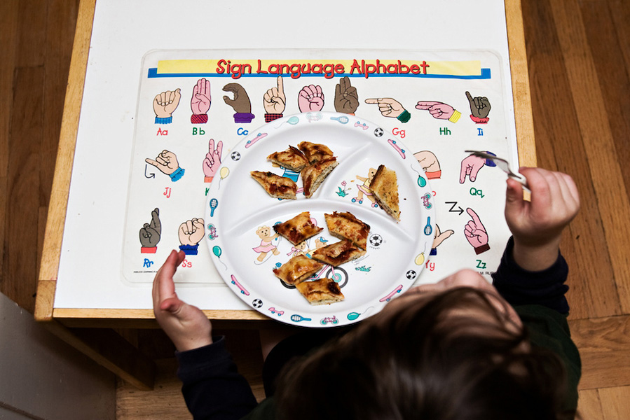 B eats dinner over a sign language placemat, just one of many ASL-themed items in the family's home.