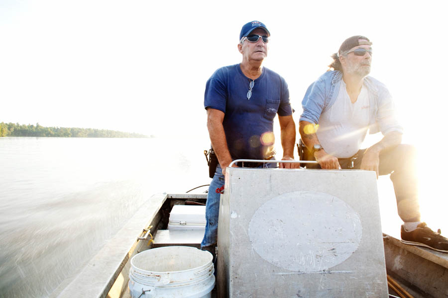 Julius Gaudet, 62, (L) and Rebel (R) glide over the tranquil surface early in the morning as they begin their day hunting for alligators near Shell Island, Louisiana on September 19, 2009.